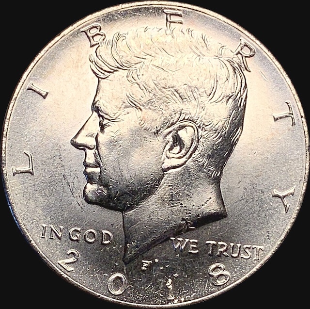 2018-P Kennedy half dollar off-center strike error — design noticeably shifted from center with exposed blank planchet area visible